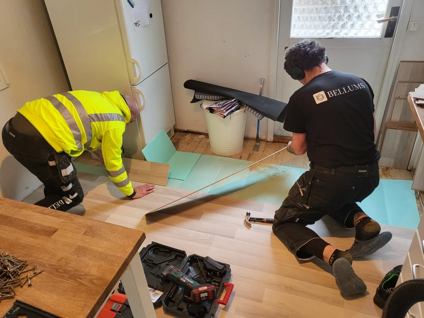 Bellums hantverkare lägger golv i lägenhet